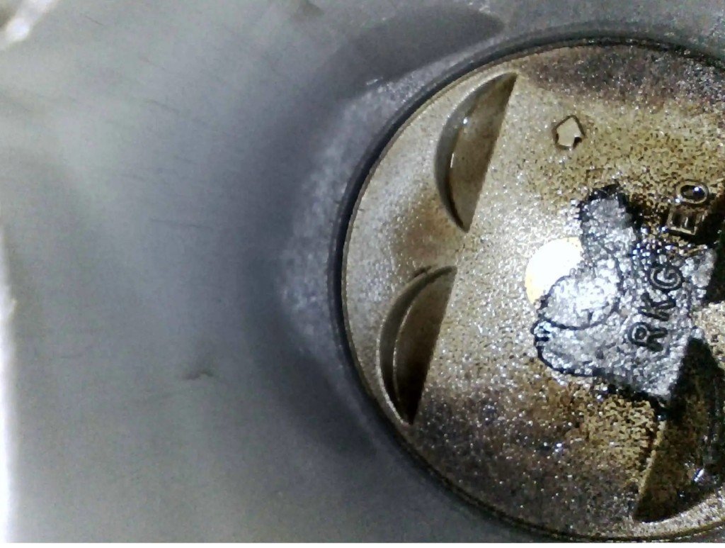 Piston crown after B-12 soak — clean metal surface